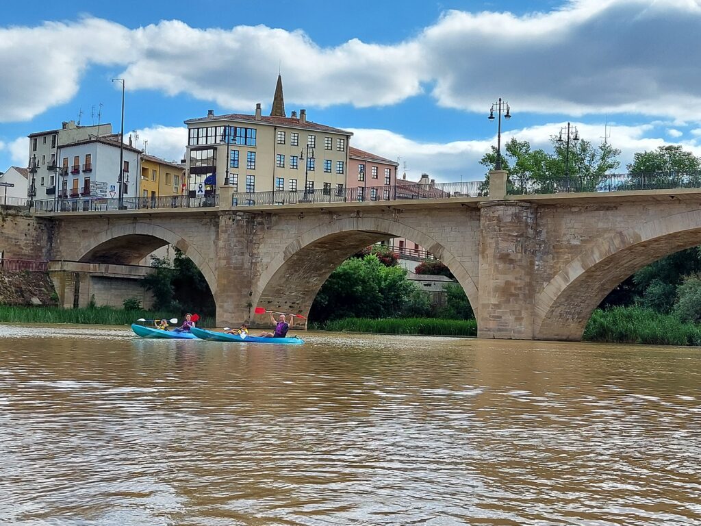Una familia haciando una travesia urbana por el rio Ebro en el centro de Logroño