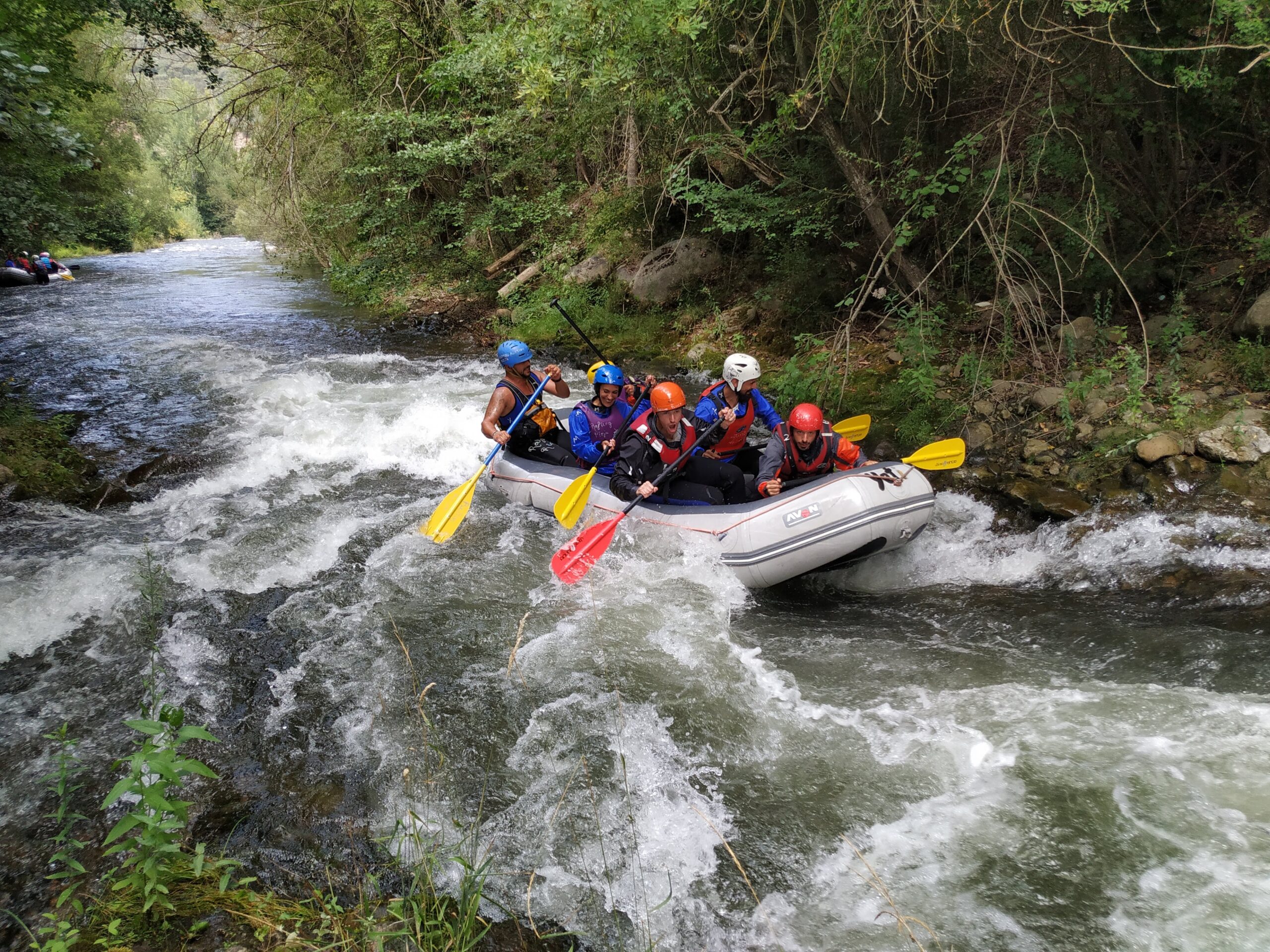 6 chicos bajando haciendo rafting por el rio